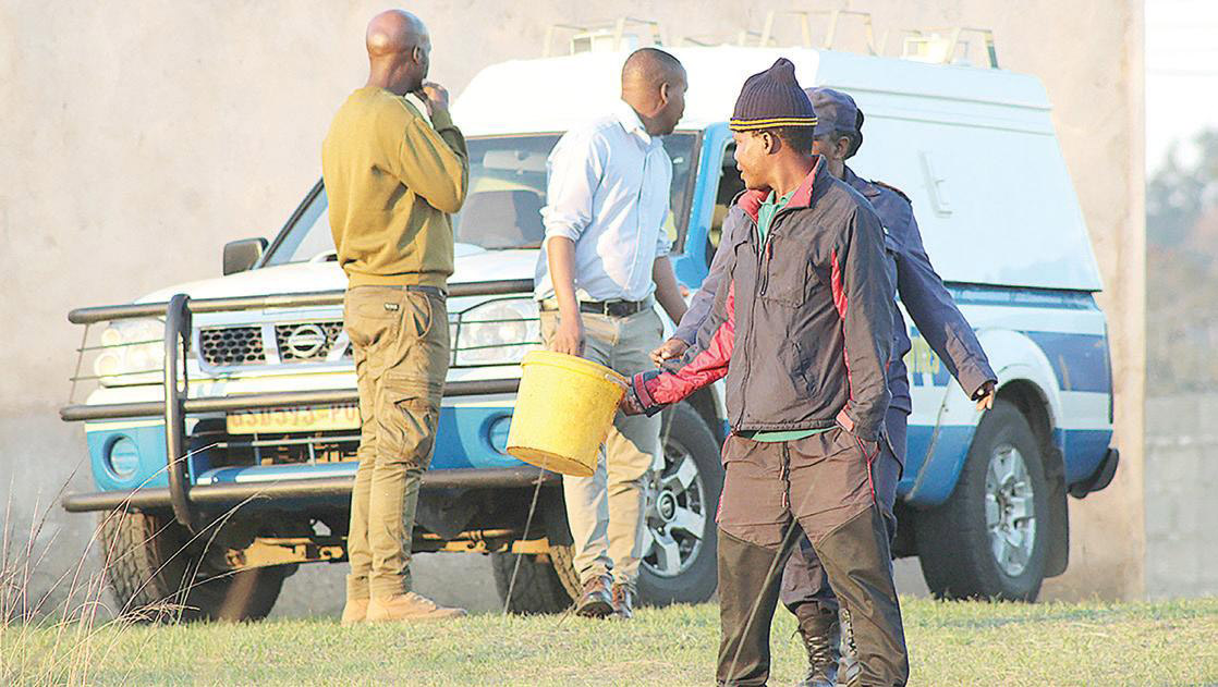 Police officers and members of the community at Mfabantfu, where the bodies were discovered.